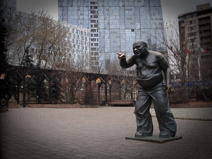 Sculpture of a man pointing in a courtyard