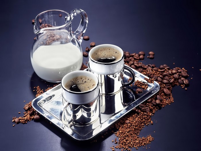 Coffee cups and milk jug with coffee beans