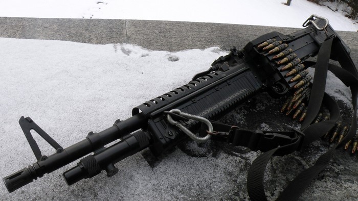 Machine gun with ammunition belt in snow