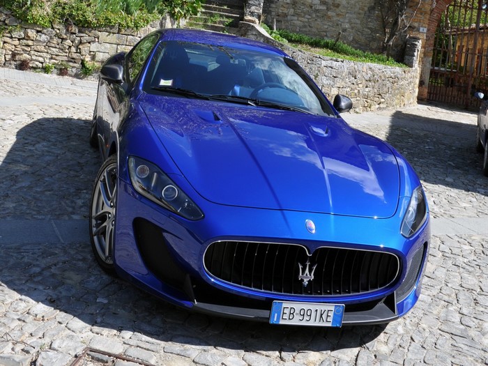 Blue Maserati GranTurismo parked on cobblestone street
