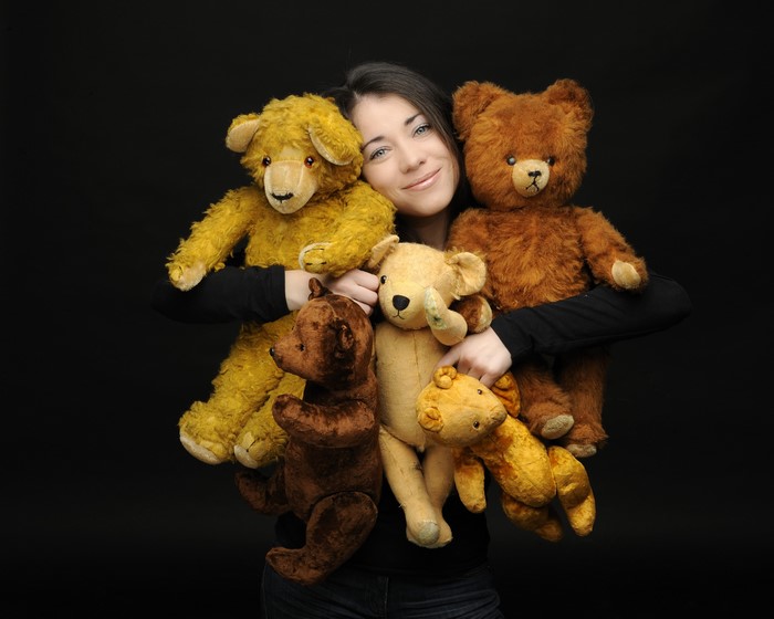 Woman holding several teddy bears