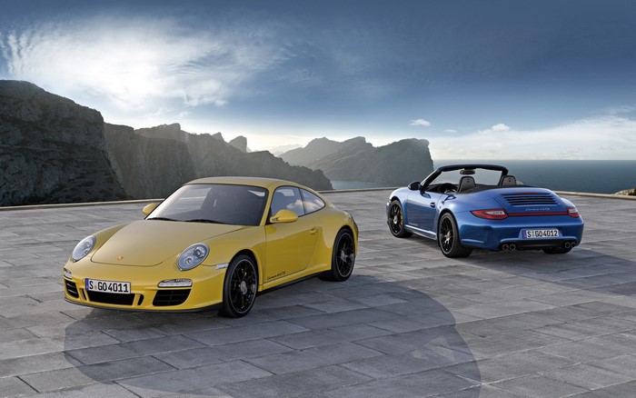 Two Porsche 911 cars on a scenic overlook