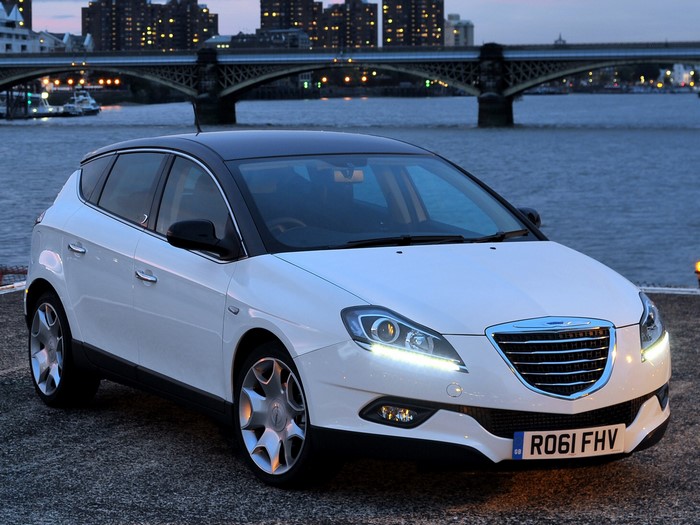 White Chrysler Delta parked by a river at dusk