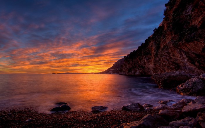 Sunset over the sea with rocky coast