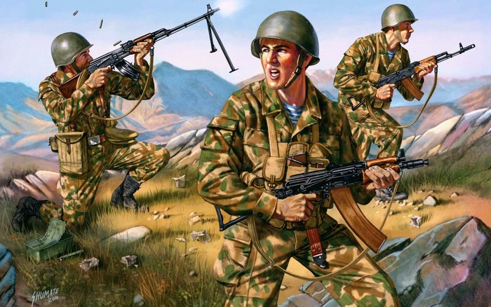 Soldiers in camouflage uniforms firing weapons in a rocky landscape
