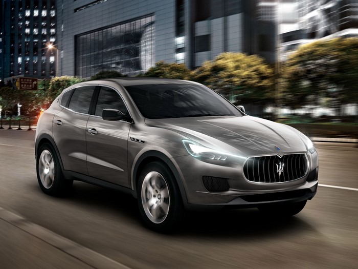 Maserati SUV driving on a city street at night