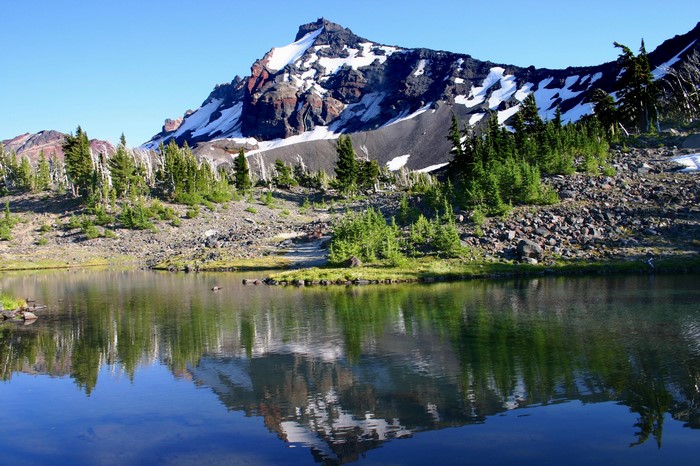 Mountain reflected in a calm lake with snow