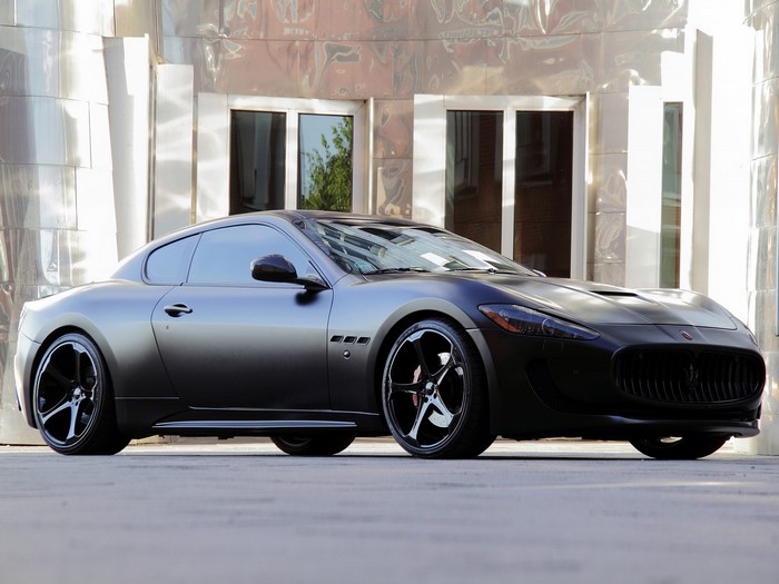 Matte black Maserati GranTurismo parked outside a modern building