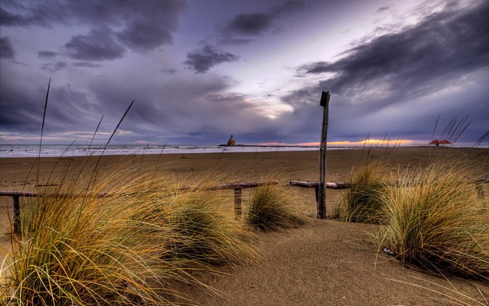 Beach with lighthouse and stormy sky