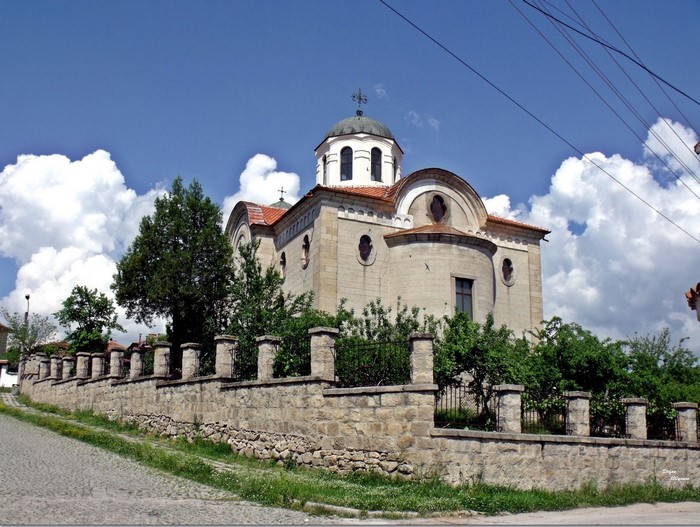 Stone church with a dome and a fence