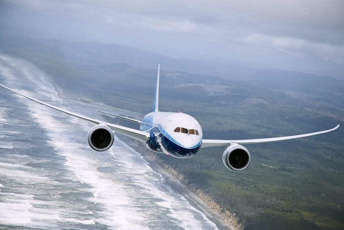 Boeing 787 Airplane flying over a coastline