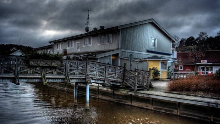 Wooden bridge leading to buildings by water