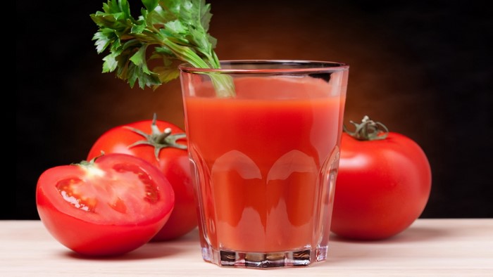 Glass of tomato juice with tomatoes and celery