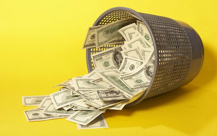 US Dollar Bills Spilling from a Trash Can