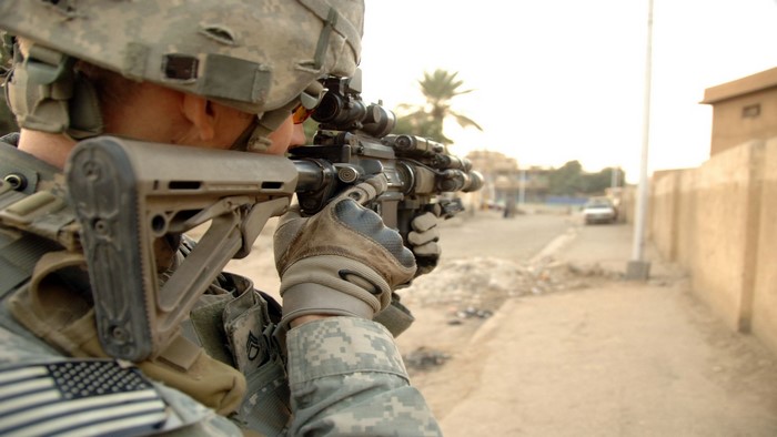 Soldier aiming rifle in a street