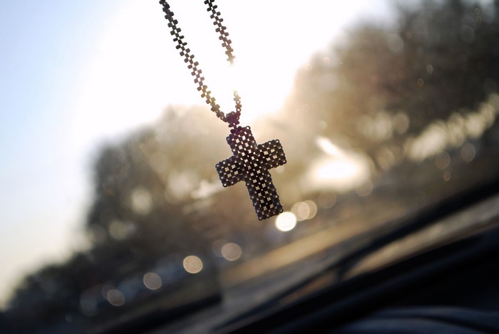 Cross necklace hanging in sunlight