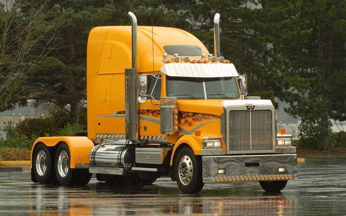 Yellow Western Star semi-truck on wet road