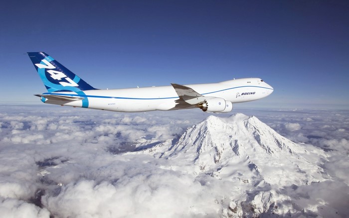 Boeing 747 airplane flying over snowy mountains