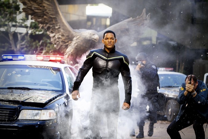 Hancock in a chaotic scene with police cars and eagle statue