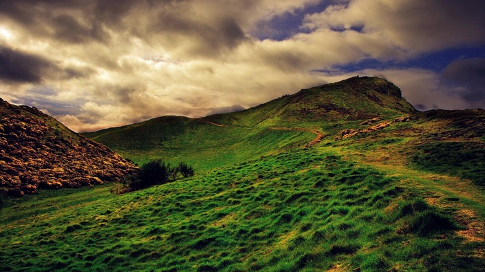 Green rolling hills under a cloudy sky