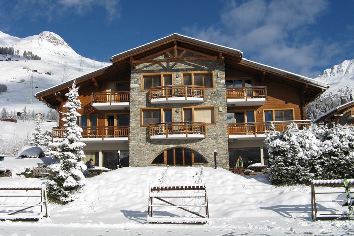 Chalet in snowy Swiss Alps with wooden balconies