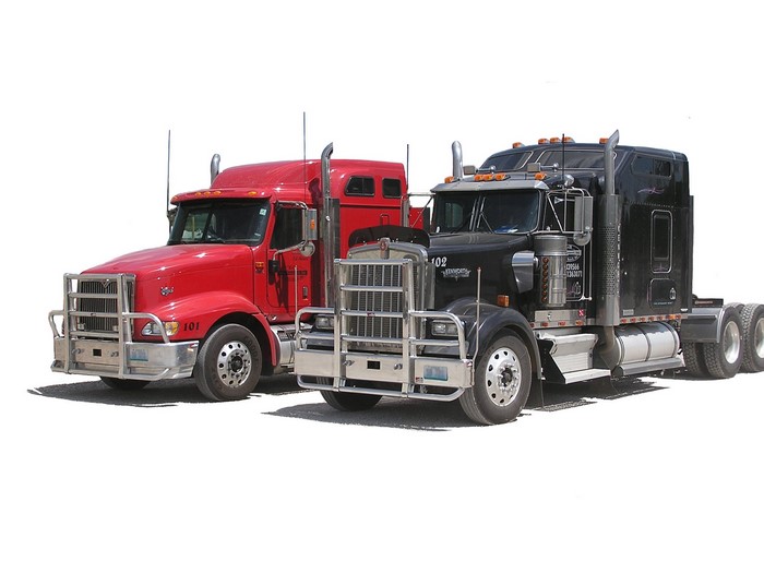 Two semi-trucks, one red and one black Kenworth