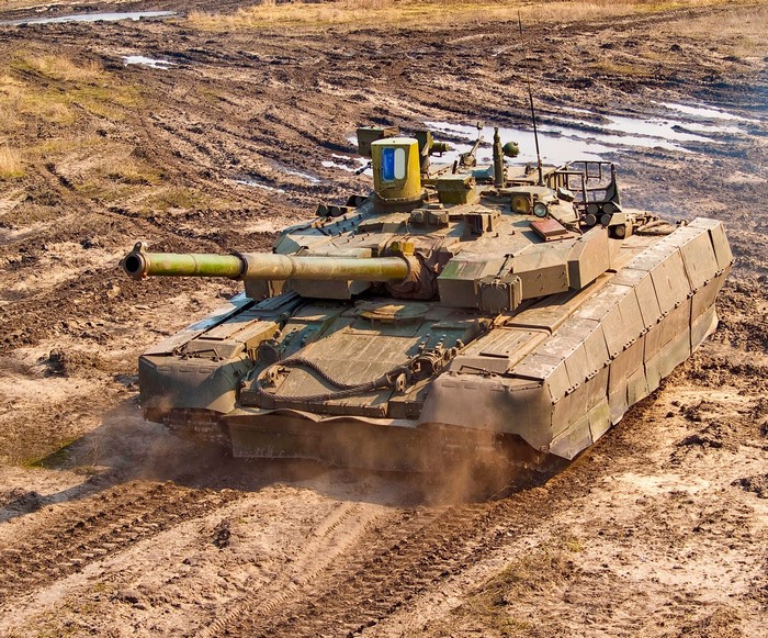 T-90 tank driving on a muddy field