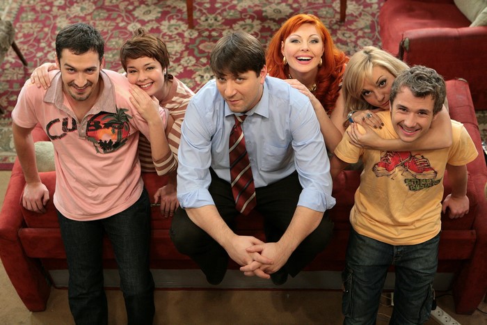 Group of six people posing on a couch