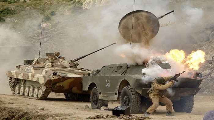 Military vehicles in combat with explosions and smoke