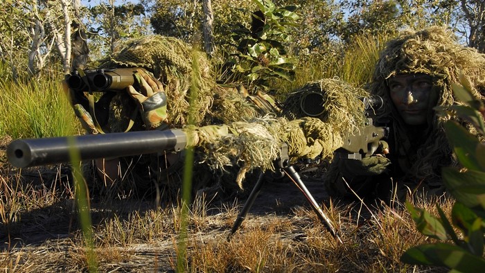 Two soldiers in ghillie suits with a sniper rifle