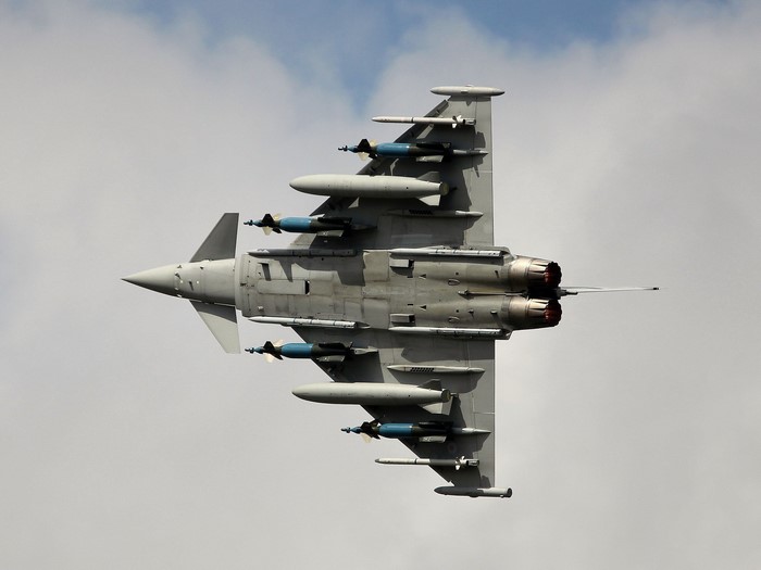 Fighter jet with bombs flying in the sky