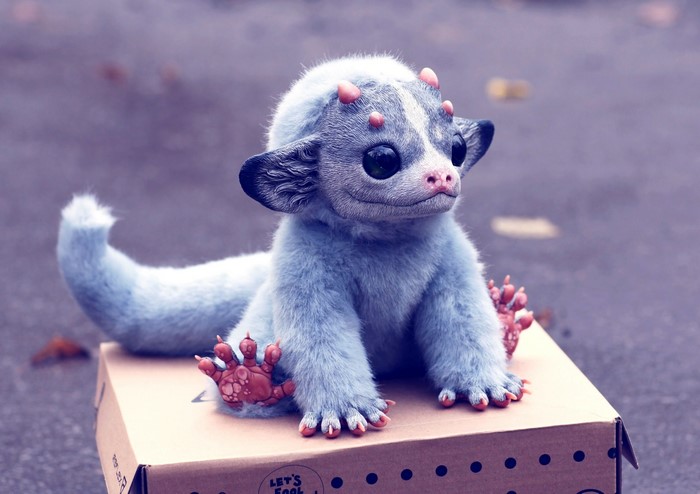 A blue fantasy creature toy sitting on a box