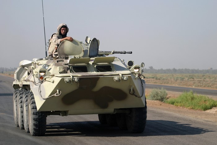 Soldier in military vehicle on a road