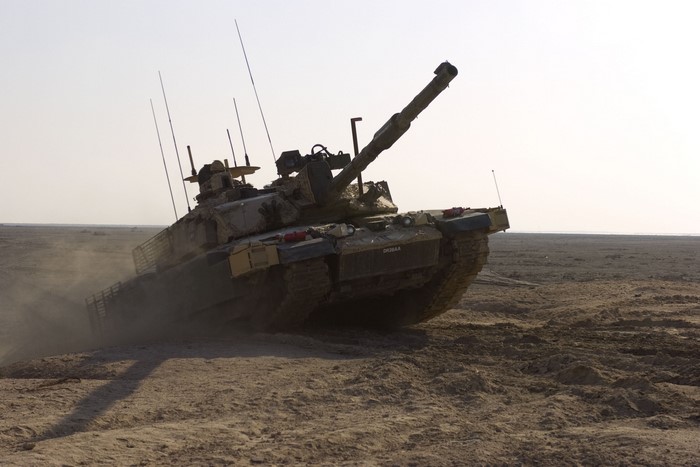 Tank driving through a desert landscape