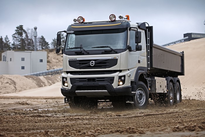 Volvo FMX 450 dump truck driving through mud