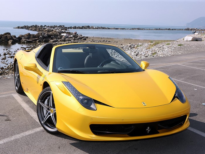 Yellow Ferrari 458 Spider parked by the sea