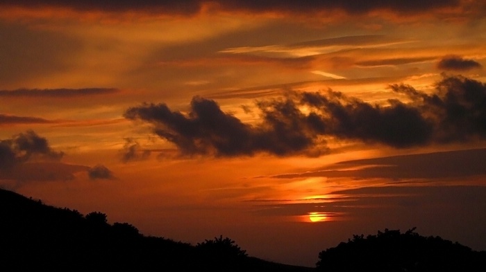 Sunset over a silhouetted landscape