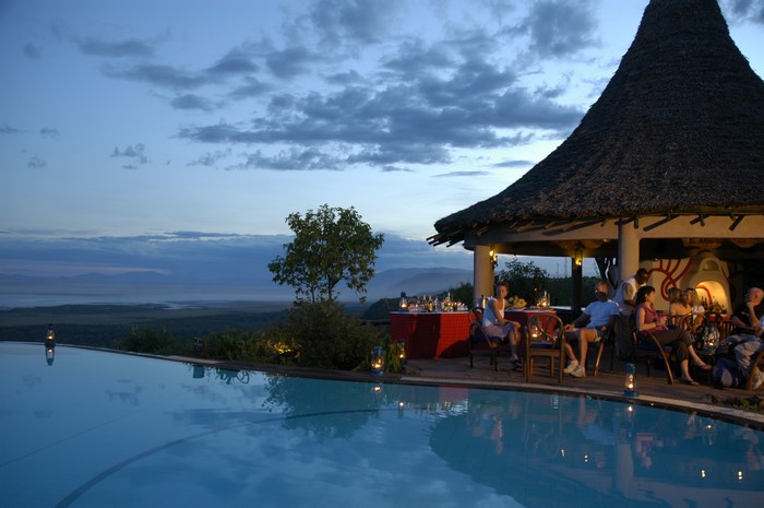 Resort infinity pool and dining area at dusk