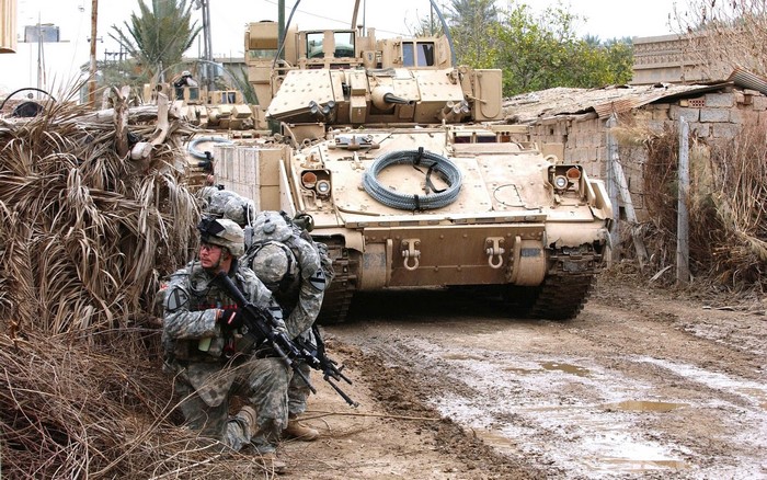 Soldiers with Bradley Fighting Vehicle in a village