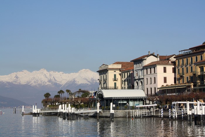 Buildings on a lake with snow-capped mountains in Como, Italy