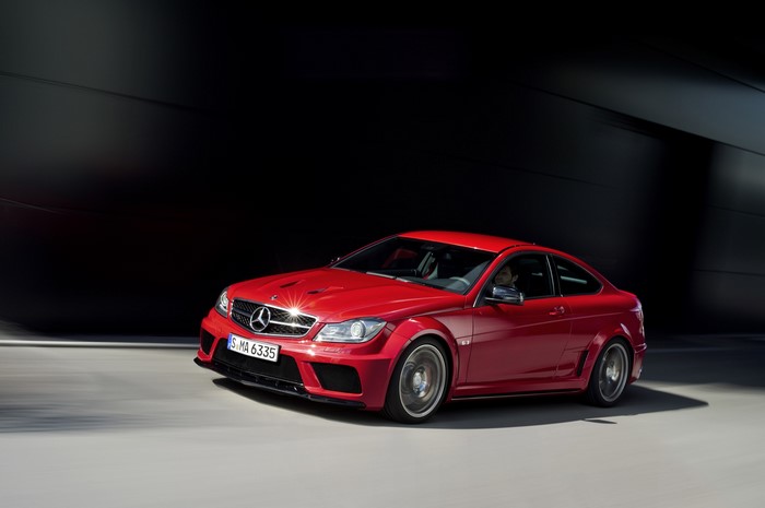 Red Mercedes-Benz C63 AMG Coupe driving