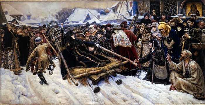 A crowd watches a woman on a sled in the snow