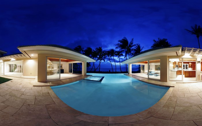 Luxury resort pool at dusk with palm trees