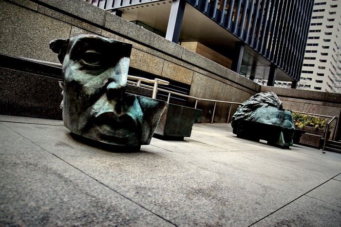 Sculptures of faces in a city plaza