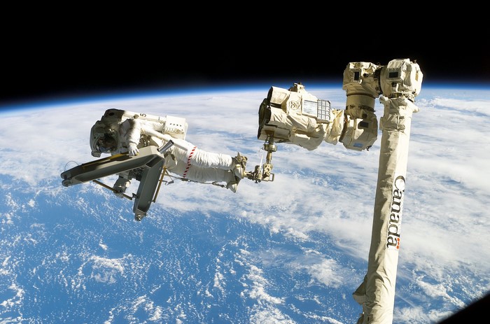 Astronaut on Canadarm2 with Earth in background