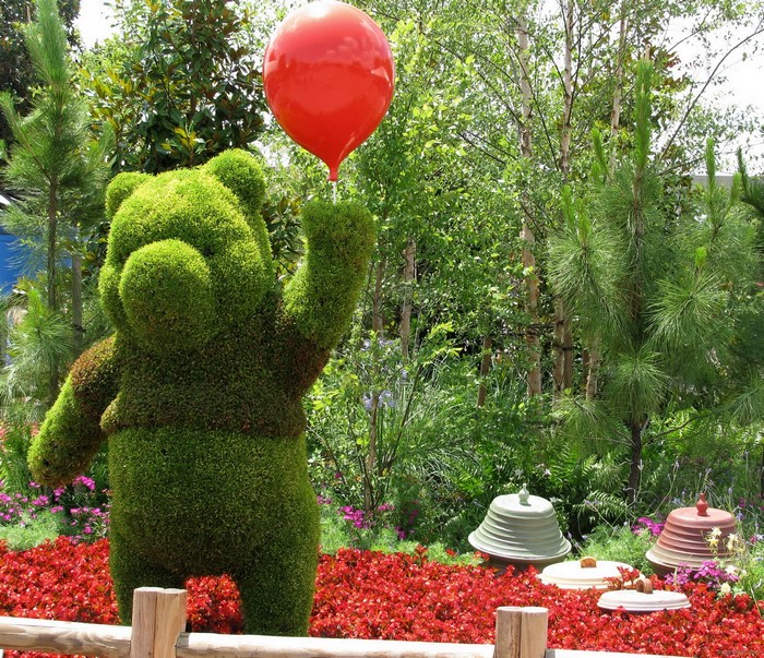 Winnie-the-Pooh topiary holding a red balloon