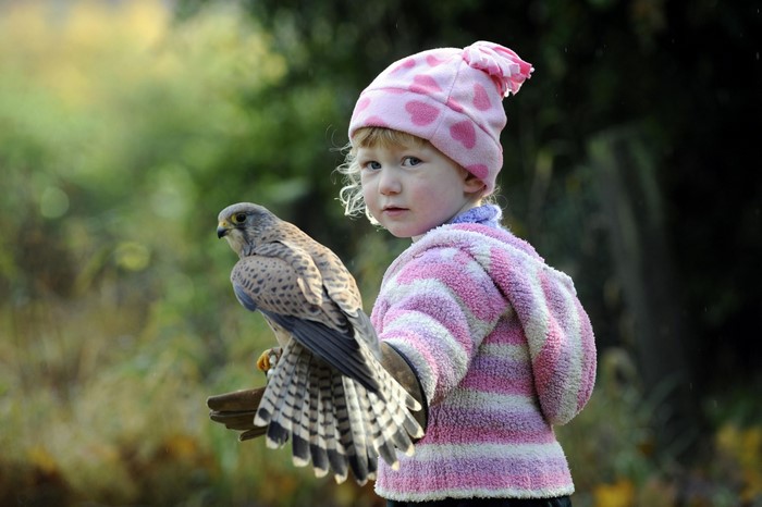 Girl holding a falcon