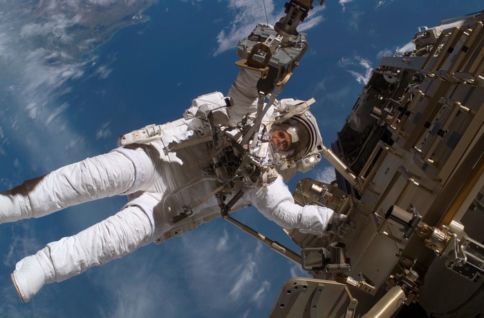 Astronaut performing spacewalk outside International Space Station