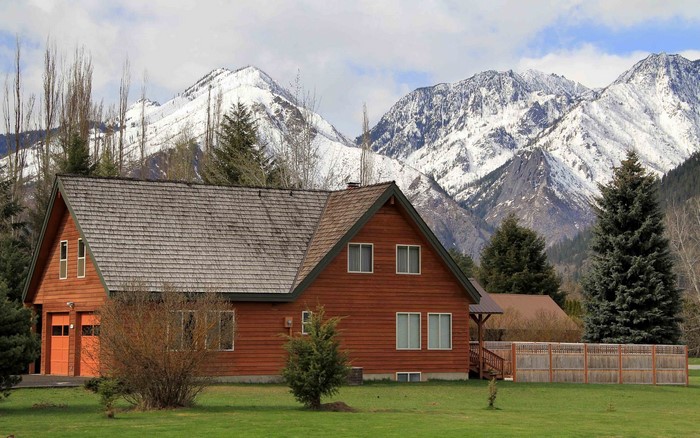 Wooden house with snow-capped mountains in the background