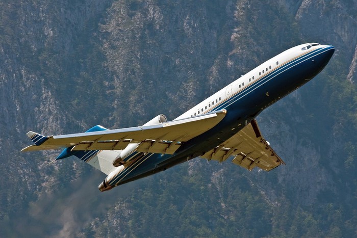Boeing 727 airplane flying over mountains